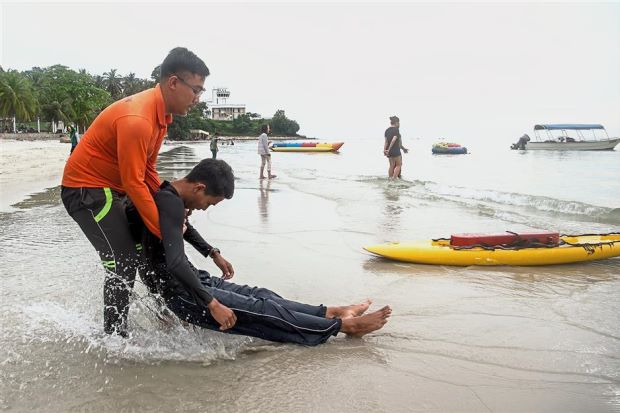 Bernama One of the lifeguards on duty demonstrating a rescue technique at Pantai Teluk Kemang, Port Dickson.